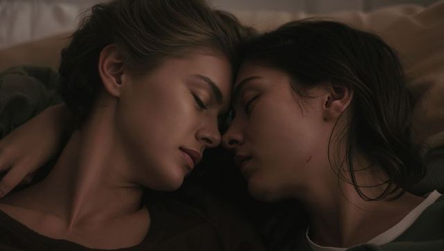 Two women cuddling in tender bedroom embrace closeup conveying intimacy, calm, softness