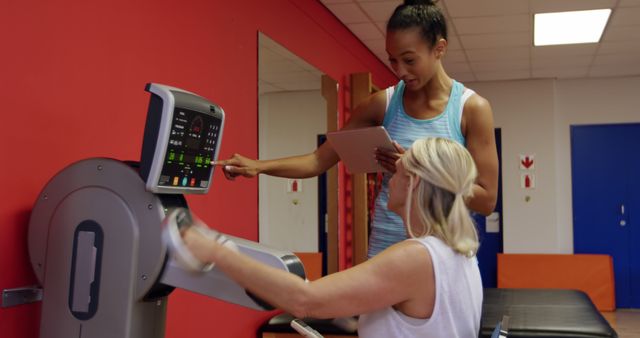 Female Trainer Guiding Senior Woman on Exercise Machine at Gym - Download Free Stock Images Pikwizard.com