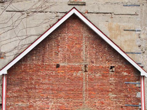 Geometric brick wall design with rustic red triangle roof