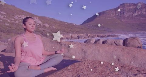 Woman Meditating on Coastal Boulder with Starry Overlay