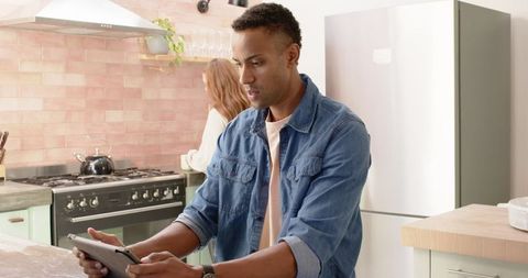 Couple in Modern Kitchen with Tablet and Cooking Appliances