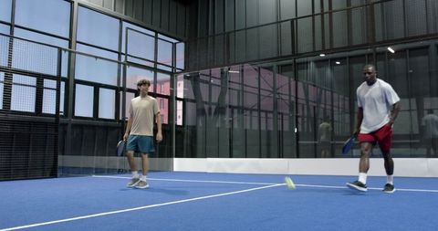Two Men Engaging in Exciting Padel Game on Modern Court
