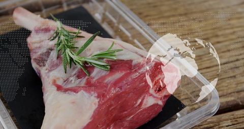 Raw lamb cut with rosemary and digital overlay on rustic wood