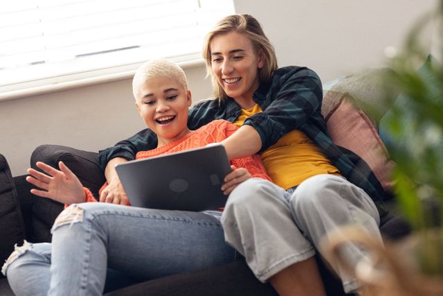 Happy Lesbian Couple Using Tablet on Sofa at Home - Download Free Stock Photos Pikwizard.com