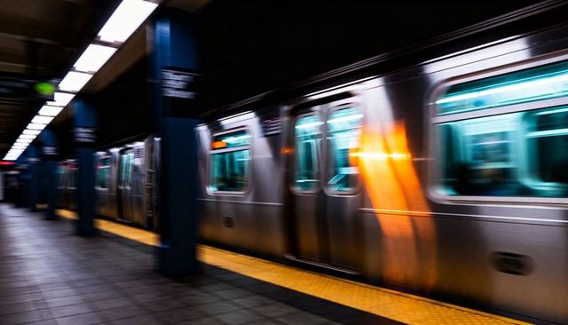 Rushing Subway Train Creating Motion Blur on Underground Platform With Neon Reflections