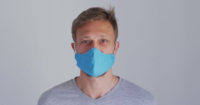 Man Wearing Blue Mask Looking at Camera in Studio - Download Free Stock Images Pikwizard.com