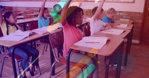 Elementary students raising hands in classroom showing active participation and focus