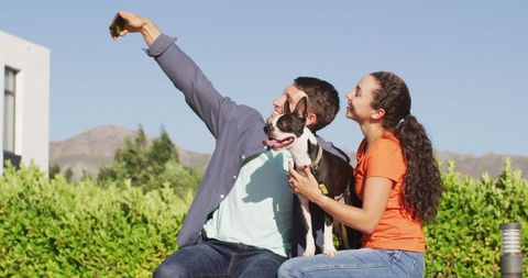 Couple Taking Selfie with Dog in Sunny Garden