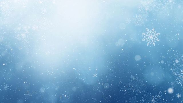 Dreamy blue winter background with drifting snowflakes, soft bokeh and gentle light