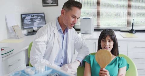 Dentist Conducting Dental Consultation While Patient Holding Mirror in Modern Clinic