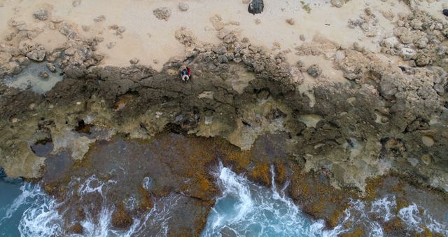 Drone view of caucasian couple sitting on beach in coastline with copy space - Download Free Stock Photos Pikwizard.com