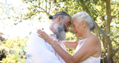 Senior couple embracing and touching foreheads in sunlit garden with molecular overlay