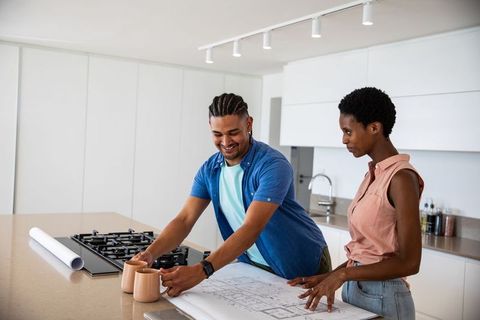 Couple reviewing home renovation plans in modern kitchen setting