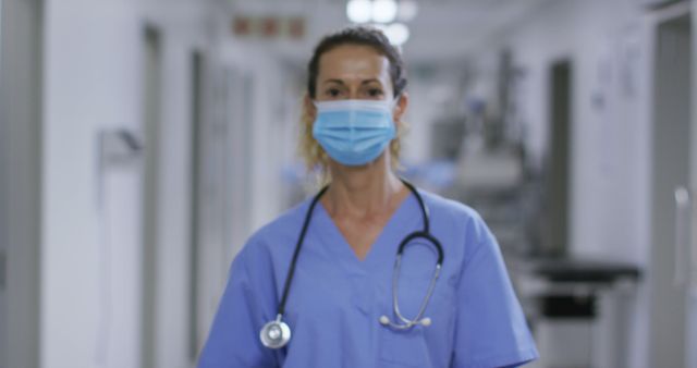 Portrait of caucasian female health worker wearing face mask in the corridor at hospital. medical healthcare during coronavirus covid 19 pandemic concept