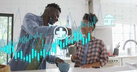 Couple analyzing financial charts over kitchen morning coffee, celebrating success