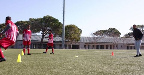 boys in red soccer uniforms practicing agility on school field - Download Free Stock Images Pikwizard.com