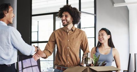 Diverse Team Greeting with Handshake in Modern Office Setting