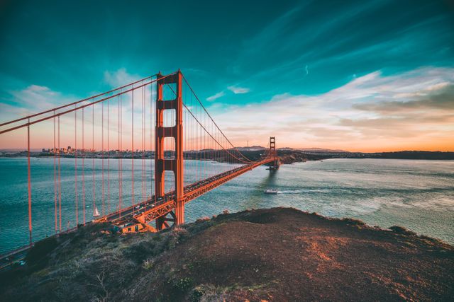 Golden Gate Bridge stretches across bay during sunset with vibrant skyline adding a picturesque backdrop. Excellent for travel websites, tourism promotions, scenic view showcases, and San Francisco related content.