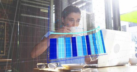 Woman sipping coffee while analyzing business bar chart on laptop with digital overlay