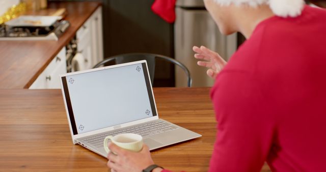 Man Wearing Santa Hat on Video Call with Laptop in Kitchen - Download Free Stock Images Pikwizard.com