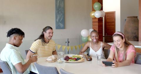 Friends Enjoying Celebration at Dining Table with Food and Drinks
