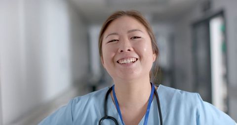 Confident Nurse Smiling in Hospital Hallway Reflects Dedication - Download Free Stock Images Pikwizard.com