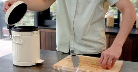 Person Composes Vegetables in Eco-Friendly Kitchen Scene