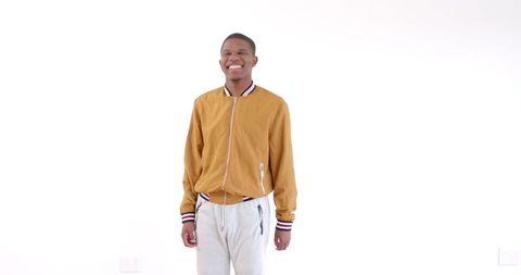 Confident young man in casual jacket smiling against white background