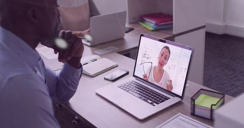 Office professional watching remote consultant demonstrating eyeglasses on laptop during virtual mee