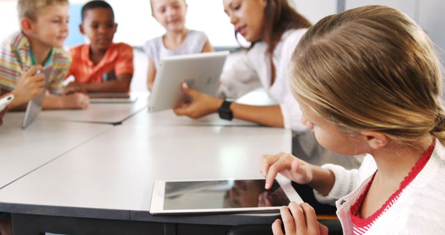 Teacher teaching kid on digital tablet in library at school