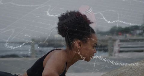 Woman doing pushups by sea with financial graph overlay