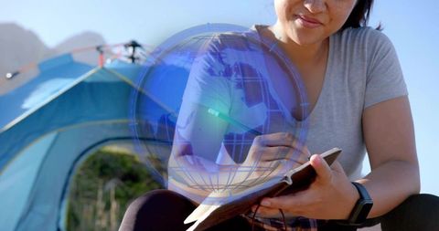 Outdoor enthusiast writing with digital globe technology