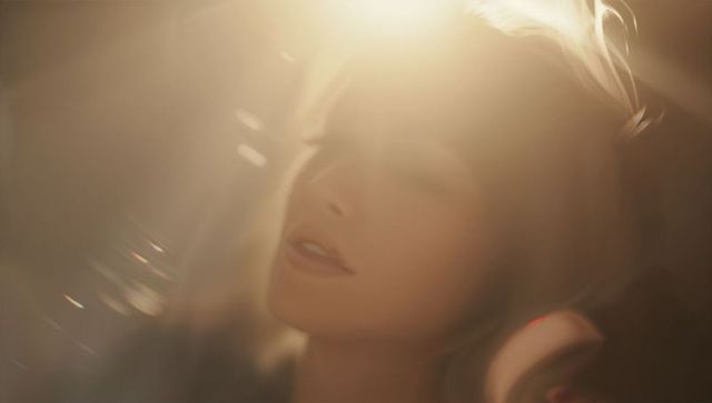 Ethereal Woman Relaxing with Music in Soft Glow