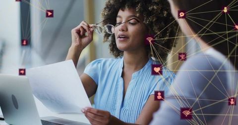 Holding document, lifting glasses, reviewing digital network for team collaboration