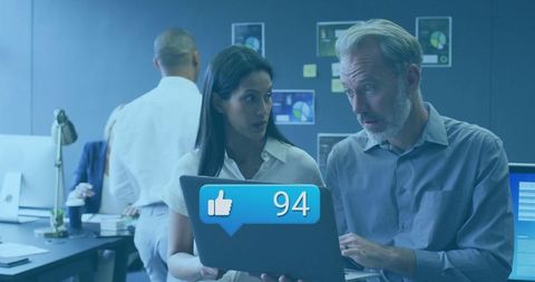 Business Professionals Analyzing Social Engagement Notification in Modern Office