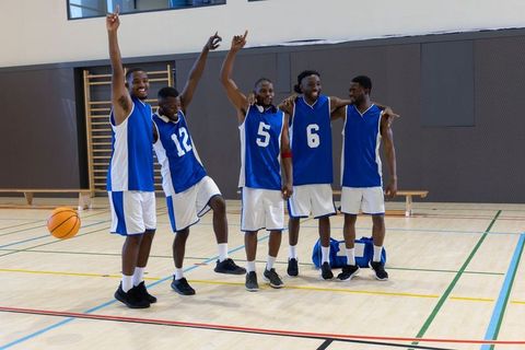 African american basketball players celebrating victory and camaraderie on indoor court