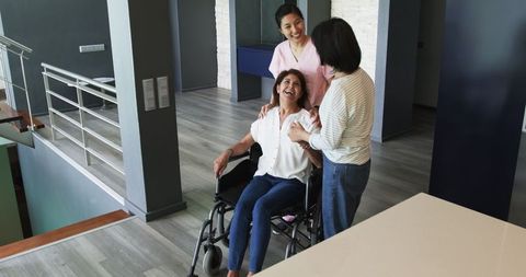 Senior Woman in Wheelchair Smiling with Supportive Friends