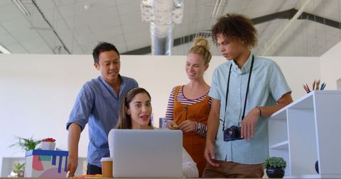Diverse Team Collaboration on Laptop in Modern Office Space