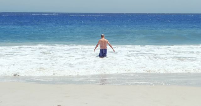 Man Enjoying Tranquil Ocean Waves on Sandy Beach - Download Free Stock Images Pikwizard.com