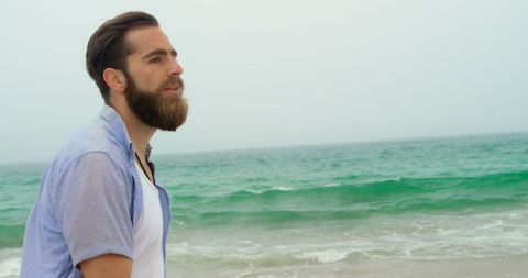 Contemplative Man Walking on Sandy Seaside Beach