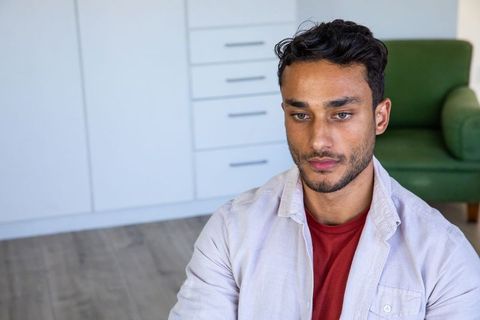 Contemplative man sitting on floor in minimalist living room