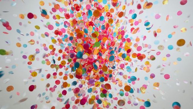 Bursting multicolor confetti cloud exploding in motion with metallic and matte circles