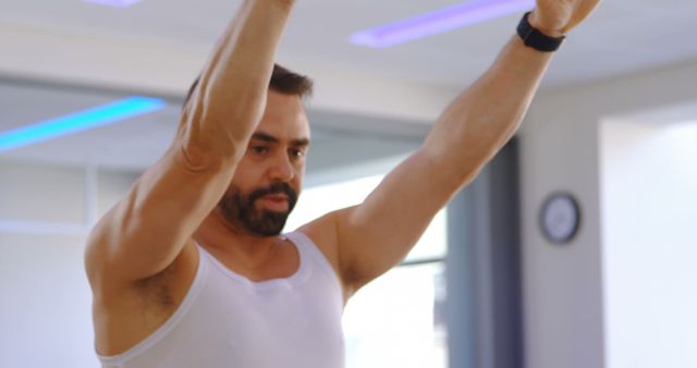 Man in White Tank Top Exercising with Raised Arms - Download Free Stock Images Pikwizard.com