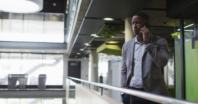 Businessman walking in modern office speaking phone - Download Free Stock Images Pikwizard.com