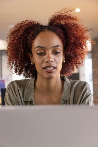 Young African American Businesswoman Working at Laptop in Open Office