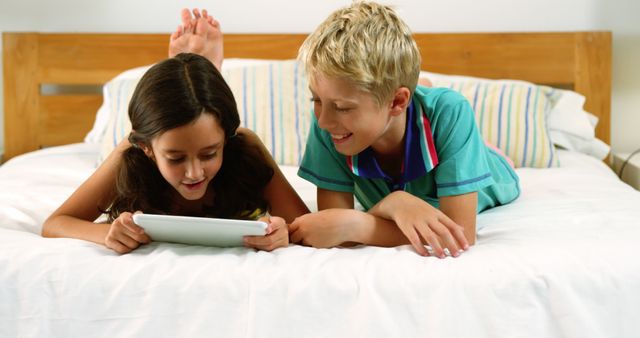 Children Using Tablet on Bed and Smiling Together - Download Free Stock Images Pikwizard.com