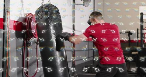 Man punching heavy bag in gym, intense boxing training and fitness workout