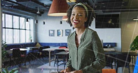 Smiling woman holding smartphone in modern coworking space