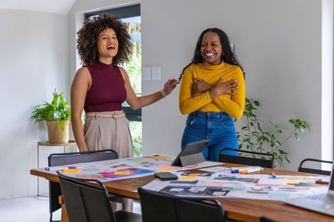 African american women celebrating creative breakthrough while collaborating on design project