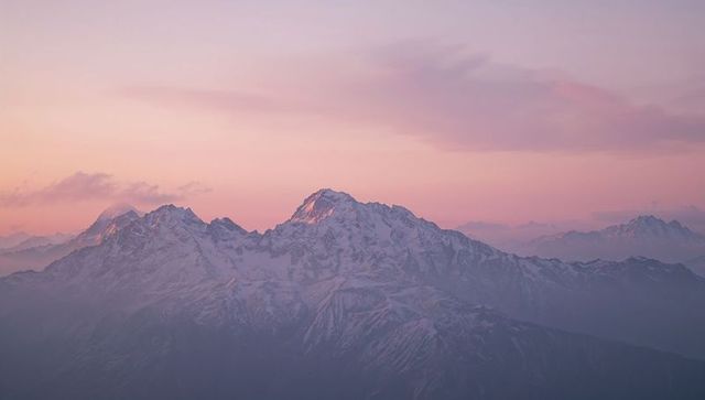 Majestic Snow-Covered Mountain Peak Under Pink Dawn Sky